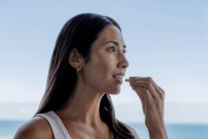 Vrouw neemt NRgize+ supplement van SynTernals
